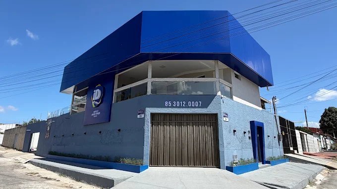 Fachada da sede do Grupo iDeal em Caucaia, prédio azul com o logotipo iD e o telefone (85) 3012-0007